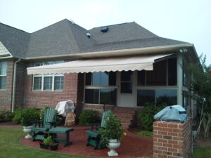 Brick house with retractable awning and patio furniture.