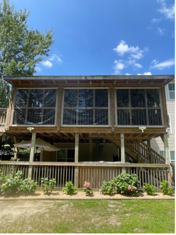 Screened porch on sunny day with landscaping.