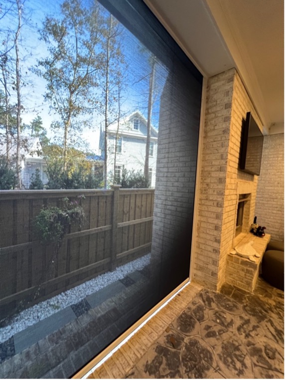 Screened porch with a wooded view and brick interior.