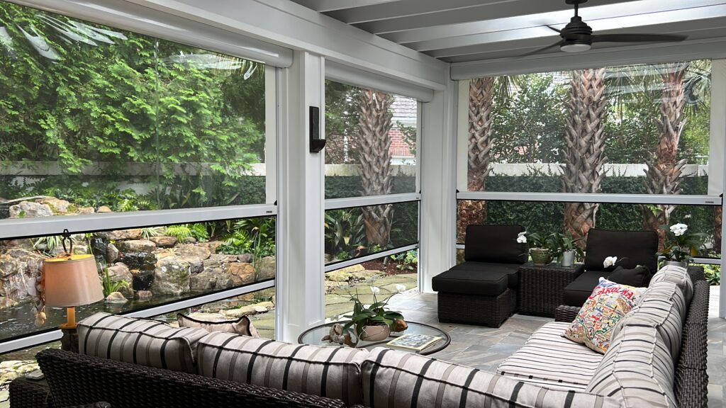 Cozy screened patio with pond view and seating.