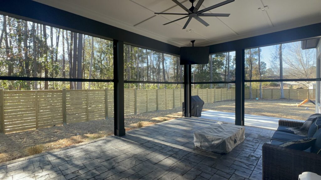 Screened porch with view of trees and fenced yard.