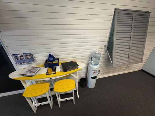 Office corner with table, chairs, and water dispenser.
