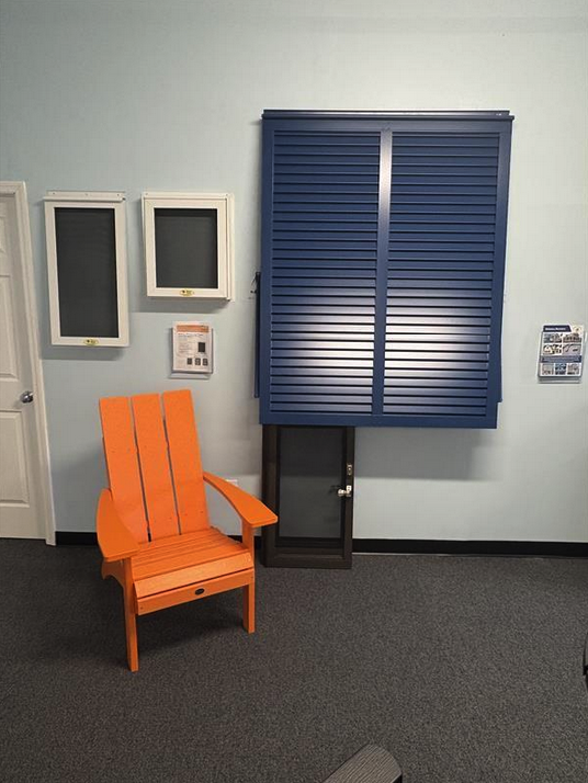 Orange chair beneath blue shutter display indoors.